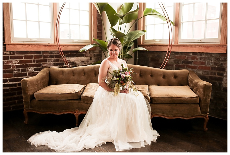 bride sitting looking down with bouquet in lap