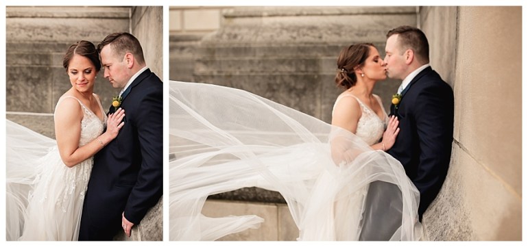 bride and groom kissing with wedding gown in wind
