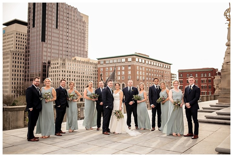 wedding party posed with city skyline in backdrop