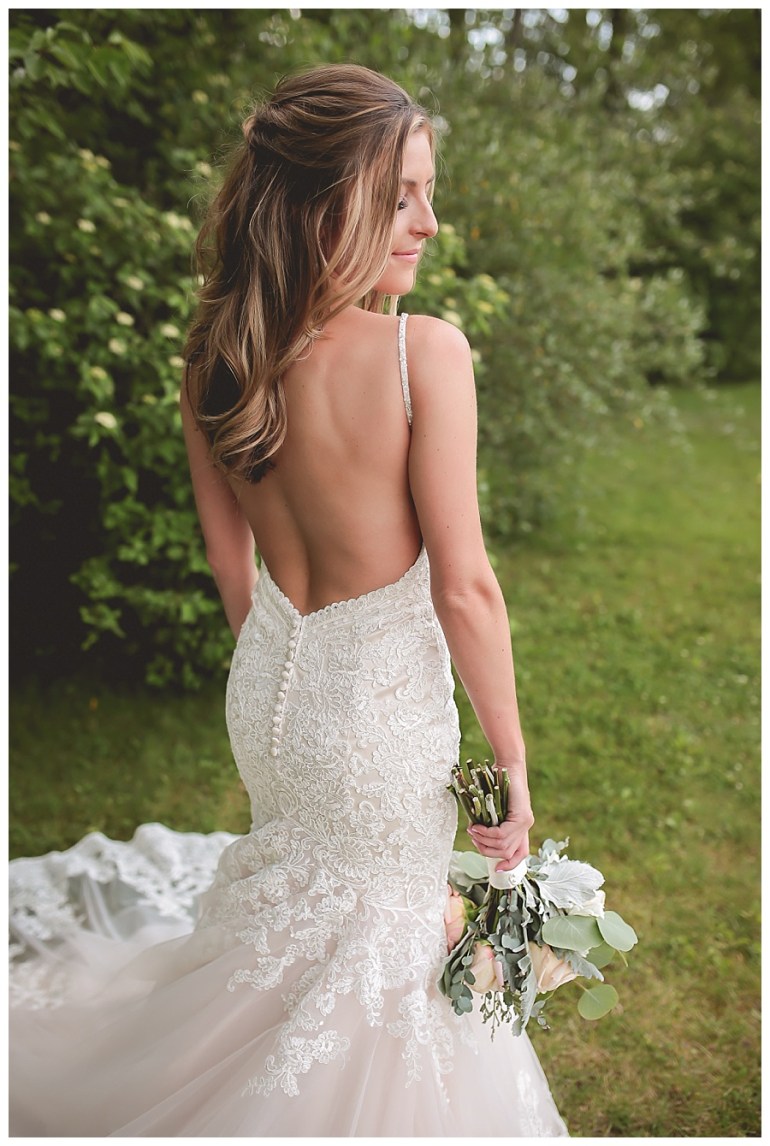 bridal gown back of bridal gown bride posed with bouquet