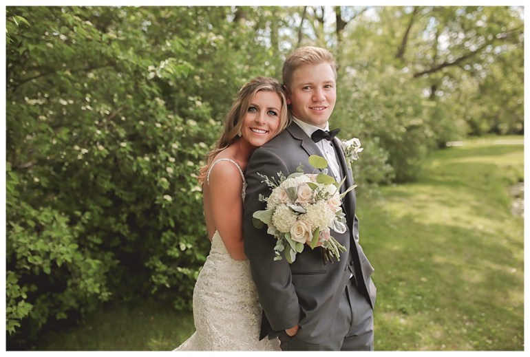 bride and groom hugging and smiling bride holding bouquet