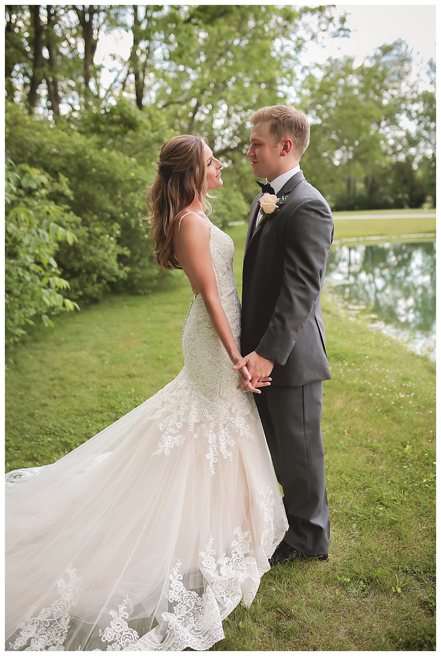 bride and groom holding hands smiling at each other